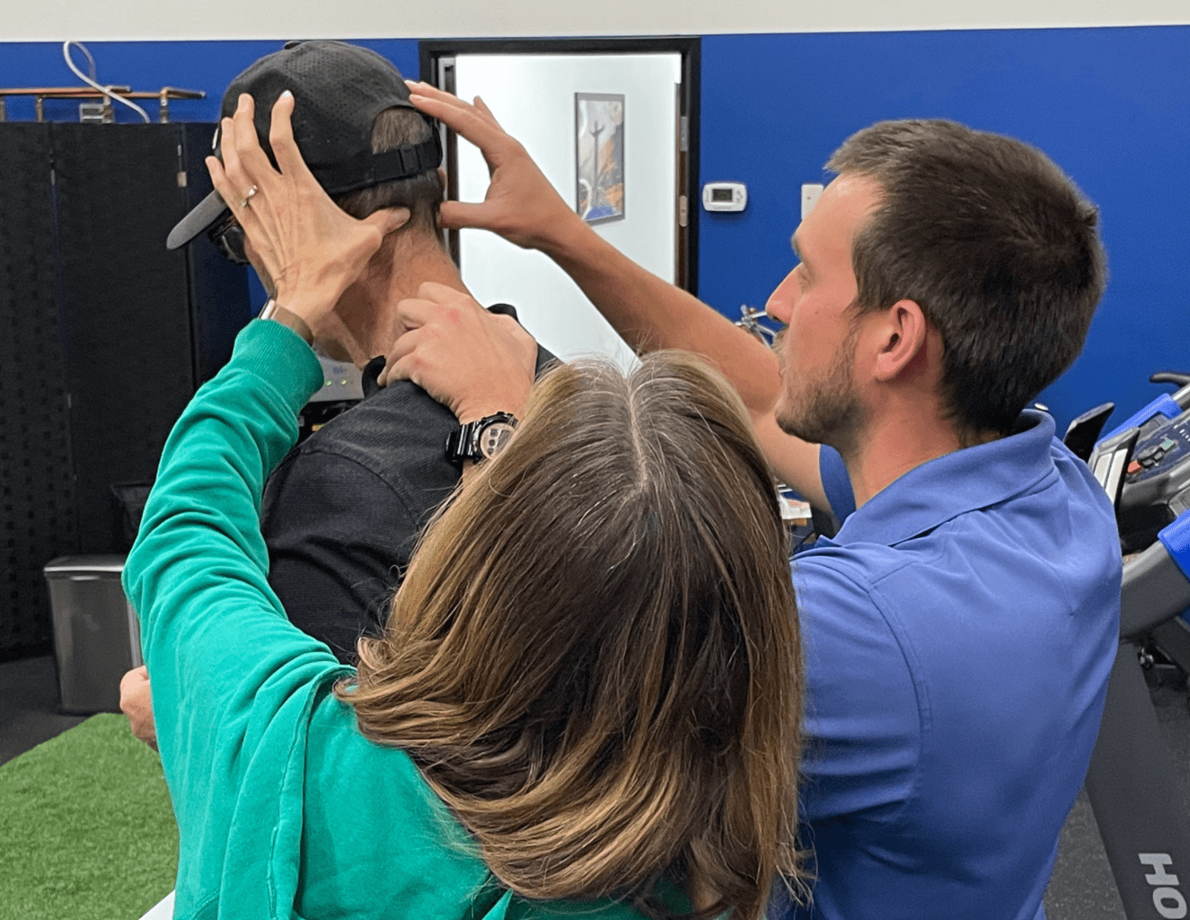 Dr. Jake showing couple how to hit tension headache trigger points
